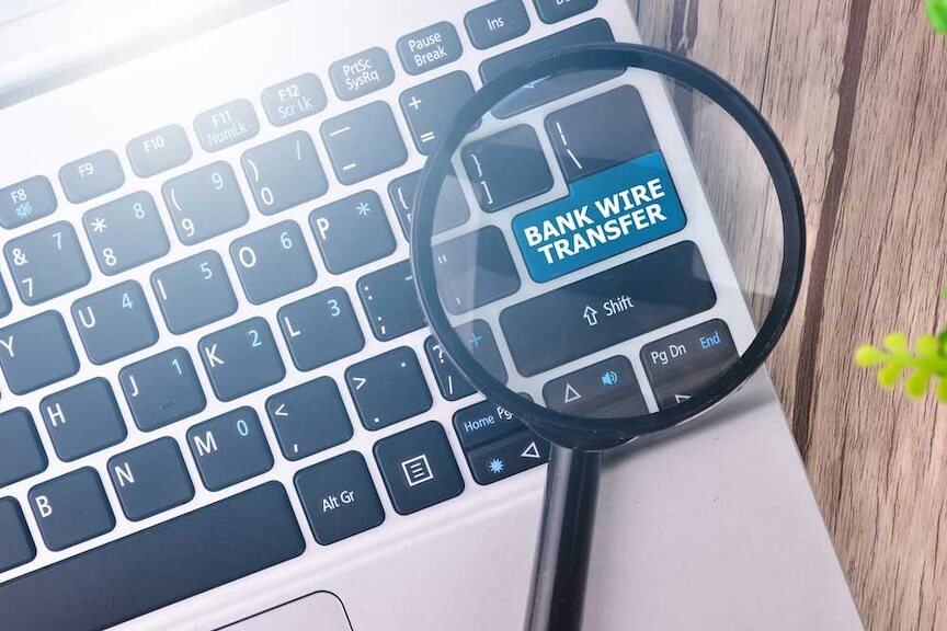 A photo of a computer keyboard with a magnifying glass on it.