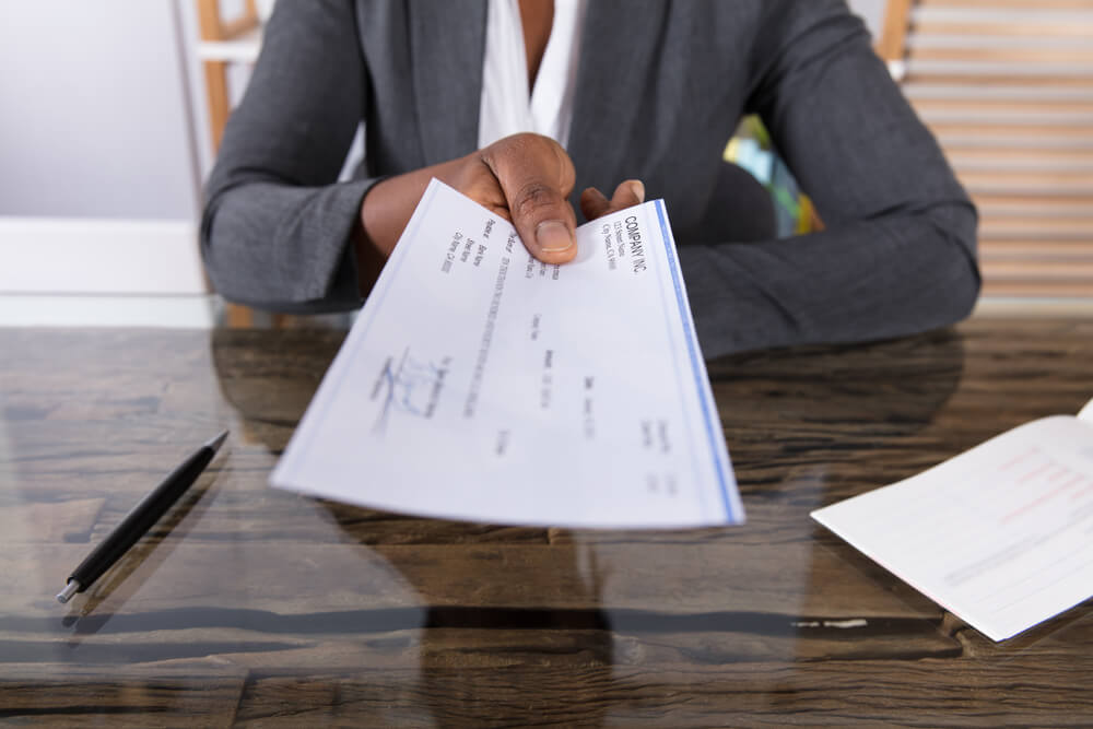 Woman Handing a Check