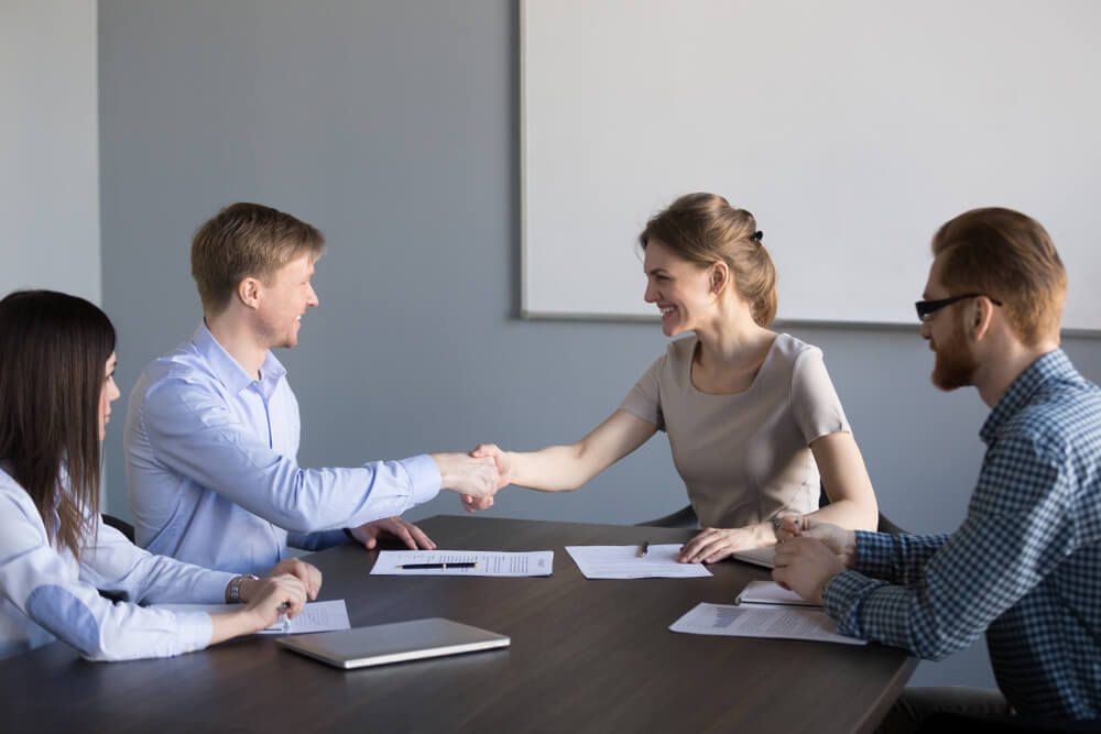 Smiling Female and Male New Partners Shaking Hands