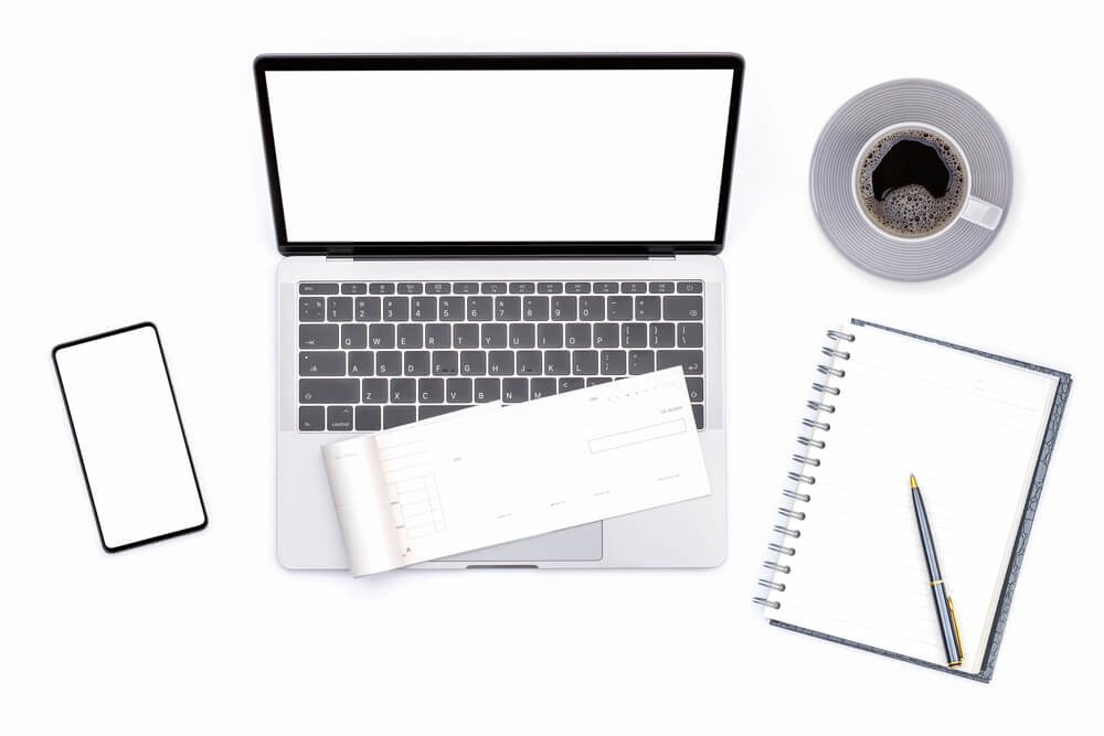 Office Desk With Laptop Computer and Blank Check Book