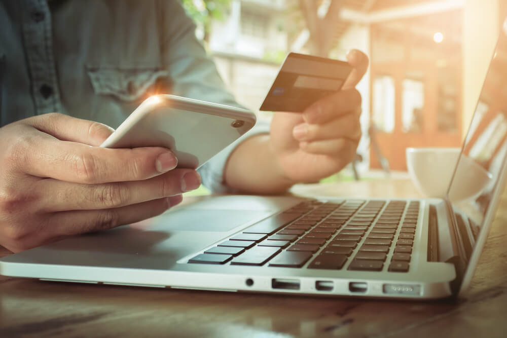 Man Holding Smartphone and Using Credit Card