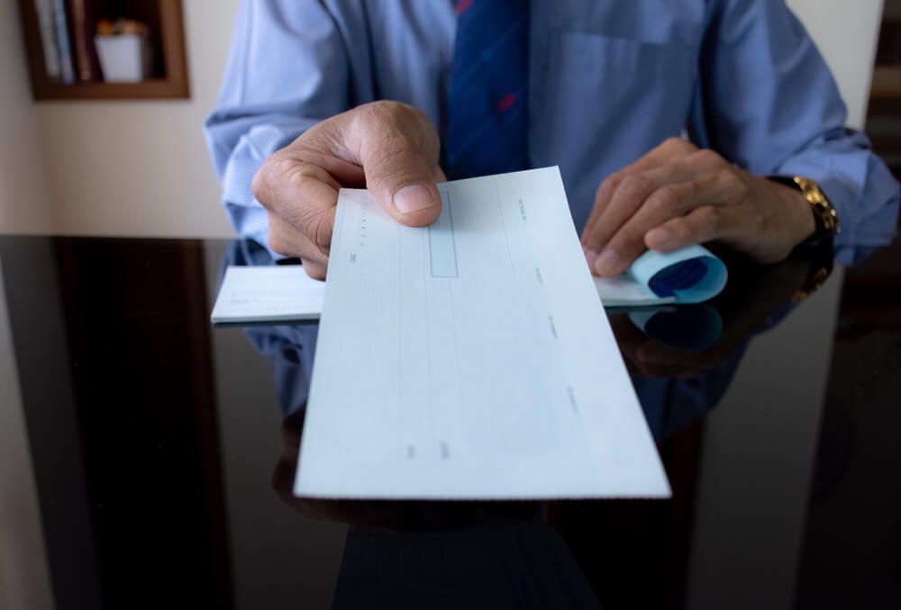 Businessman in Blue Shirt and Tie, Hand Holding Cheque