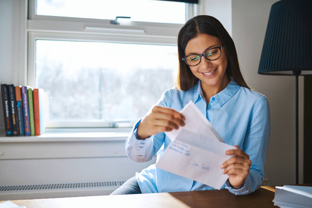 Young Business Entrepreneur Checking Her Mail Sitting at Her Desk at Home