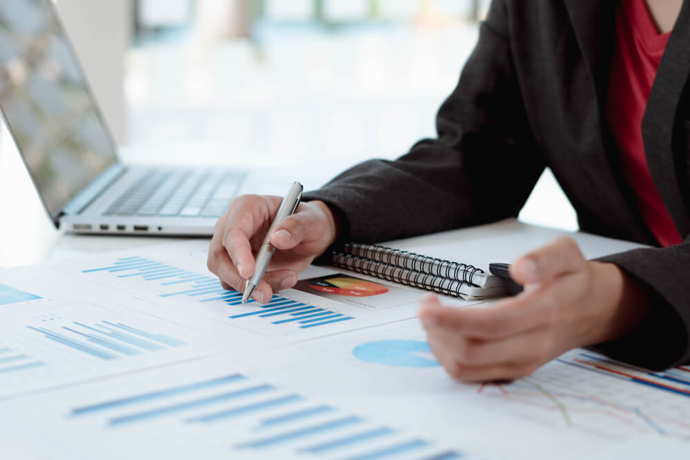 Business Women Sitting on a Laptop and Checking Business Graph Documents, Working in Financial Transactions, Accounting