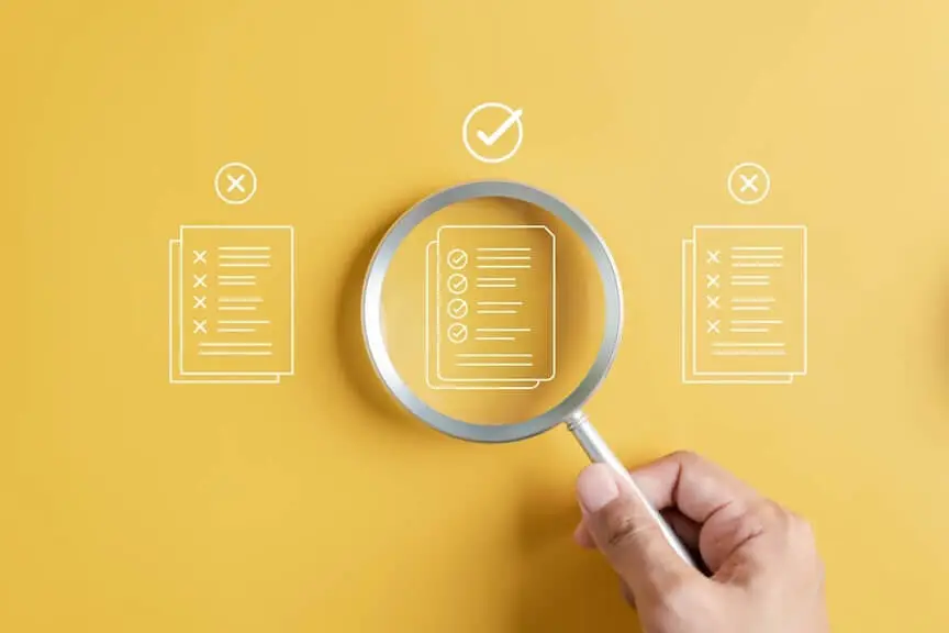 A hand holding a magnifying glass