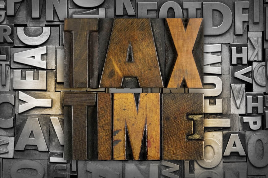 The word Tax Time carved in woodblock