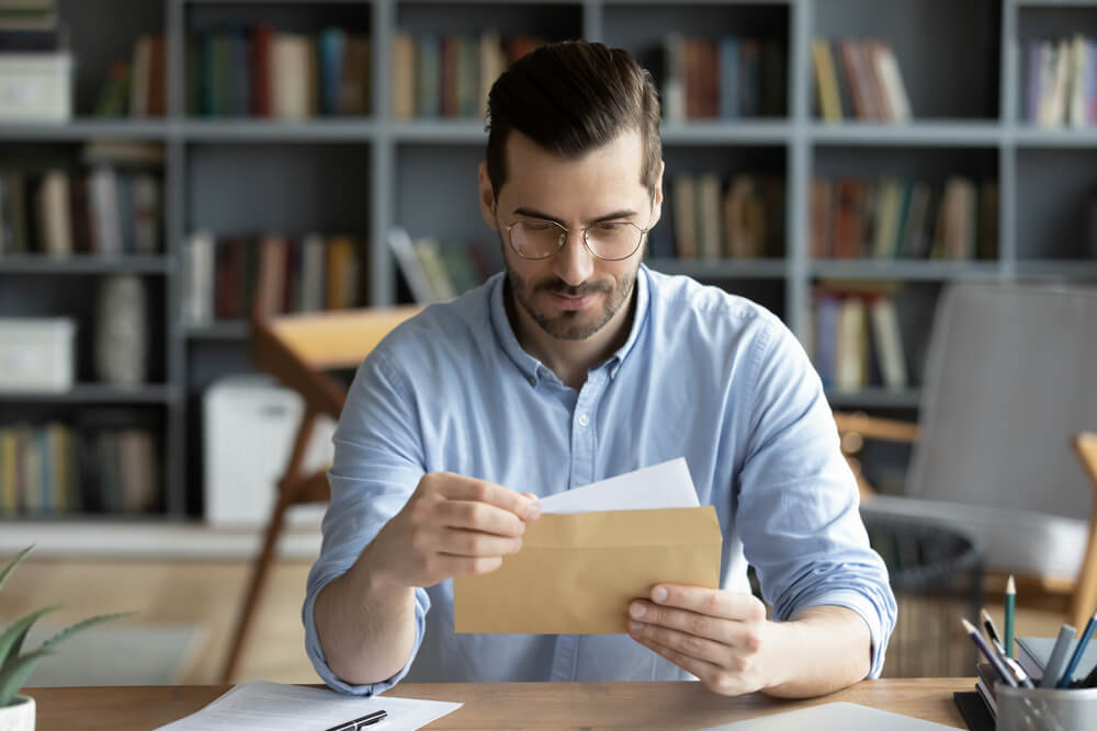 Serious Businessman Sit At Workplace Office Desk Holding Envelope Take Out Letter Feels Interested Read Business News